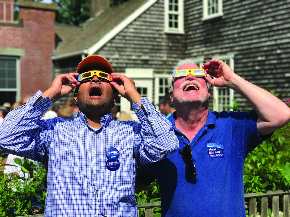 Two people looking at the sun with solar glasses